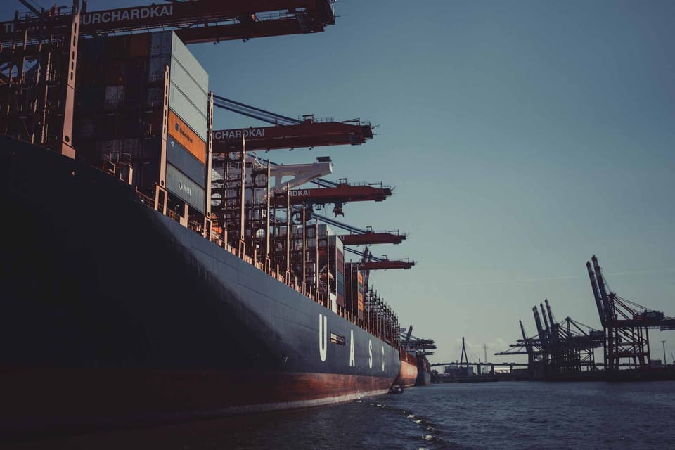 Portacontenedores atracado bajo las grúas de la terminal al atardecer
