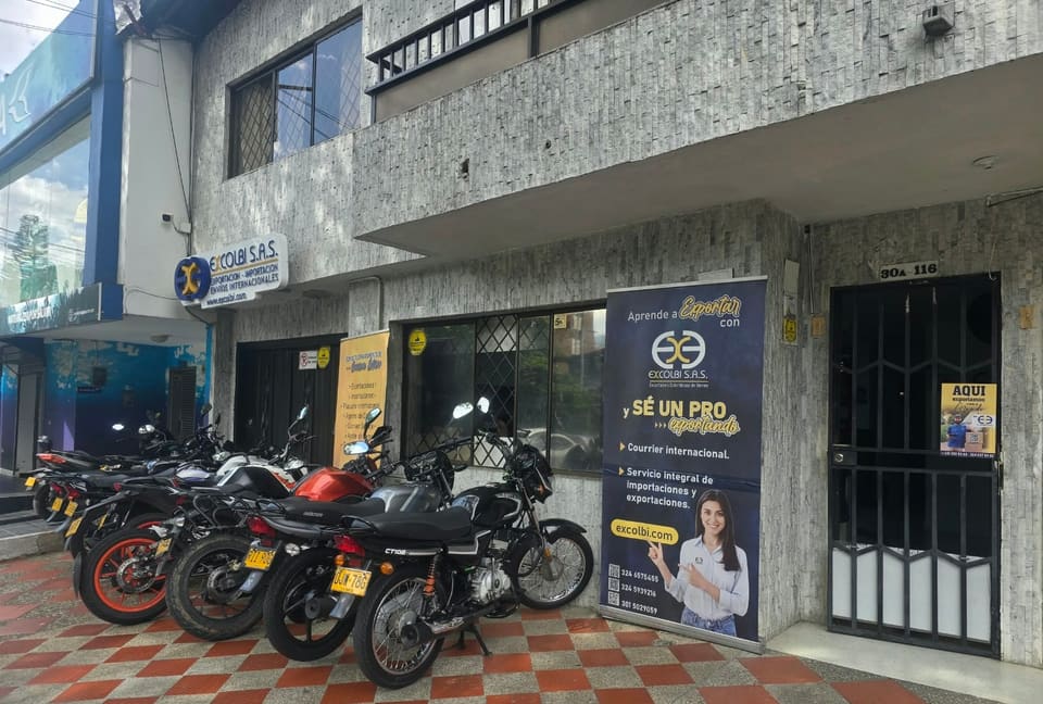 Entrada de la sede de Excolbi en Medellín, Cra. 70 # 30A-116, con el rótulo y la placa de la dirección